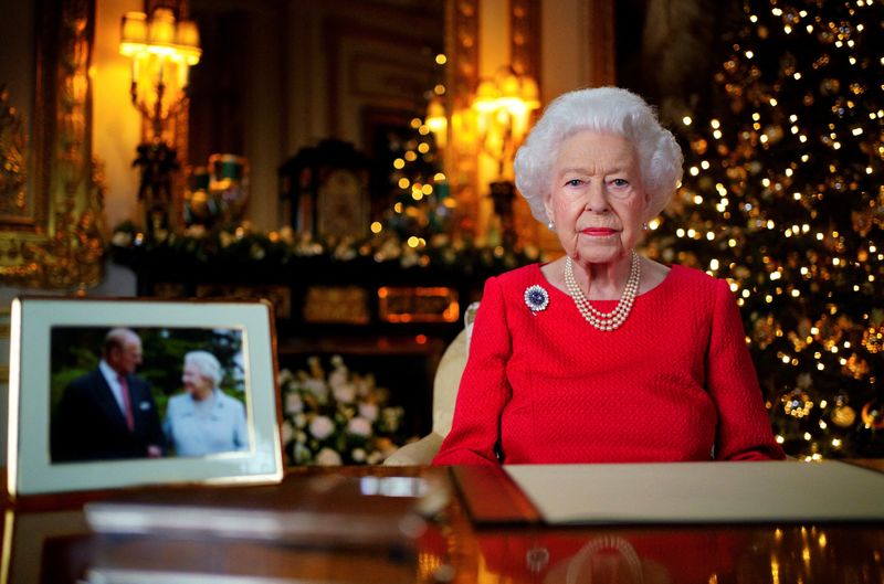&copy; Reuters. Imagen de archivo de la Reina Isabel de Reino Unido grabando su transmisión anual de Navidad en la Sala Blanca del Castillo de Windsor, junto a una fotogría de la reina y el duque de Edimburgo, en Windsor, Reino Unido. 23 de diciembre, 2021. Victoria Jo