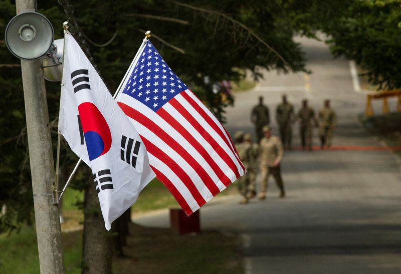 &copy; Reuters. 　在韓米軍は８日、１週間の新型コロナウイルス新規感染者数が６８２人と過去最多に上ったことを受け、警戒レベルを引き上げた。写真は韓国と米国の国旗。韓国の龍仁で２０１６年８月