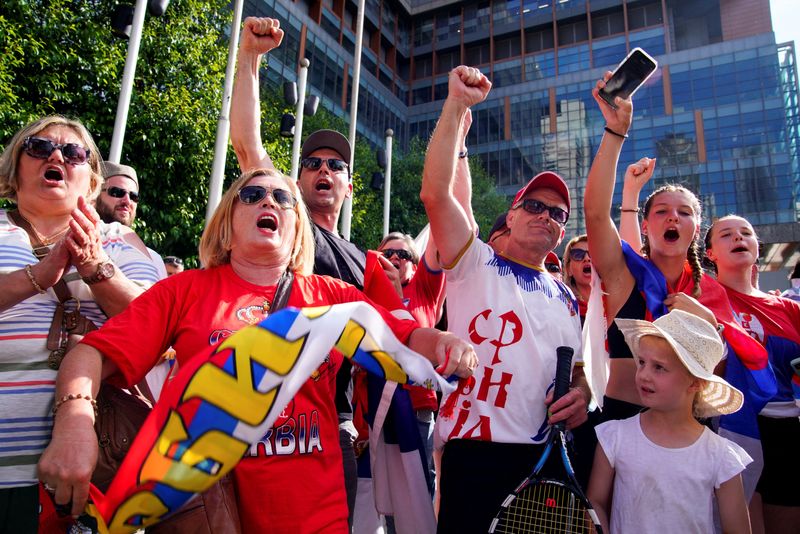 &copy; Reuters. Fans of Serbian tennis player Novak Djokovic show their support for his legal battle over his visa to enter the country and play in the Australian Open, outside the Federal Court of Australia in Melbourne, Australia, January 10, 2022. REUTERS/Sandra Sande