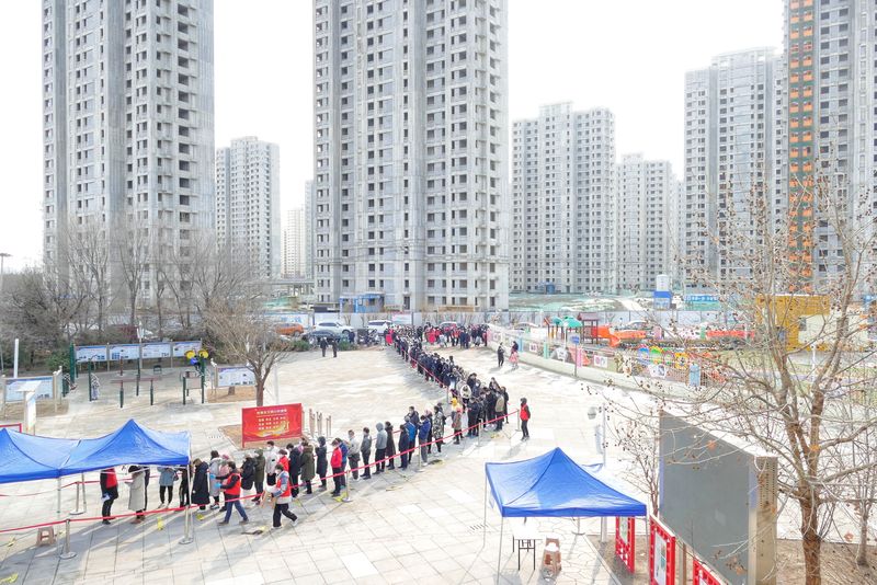 &copy; Reuters. Personas esperando durante una prueba masiva en toda la ciudad para la enfermedad del coronavirus (COVID-19) después de que se detectaran casos locales de la variante ómicron en Tianjin, China 9 de enero de 2022. cnsphoto via REUTERS   
