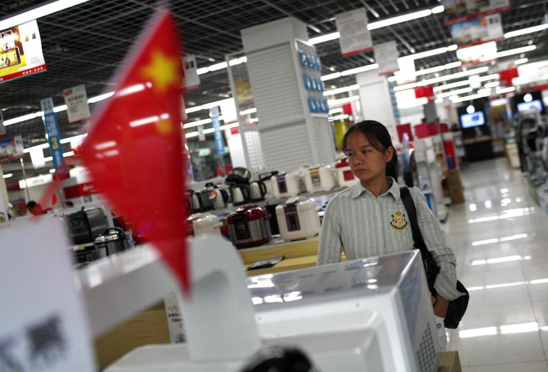 &copy; Reuters. FILE PHOTO: A woman looks at products as she shops at a local electronic store in downtown Shanghai, October 8, 2012.  REUTERS/Carlos Barria 