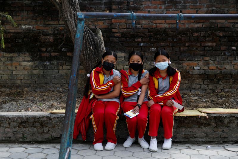 &copy; Reuters. Students sit at the premises of their school after receiving a dose of the Moderna vaccine against the coronavirus disease (COVID-19), during a vaccination drive for children aged 12-17 in Bhaktapur, Nepal, January 9, 2022. REUTERS/Navesh Chitrakar