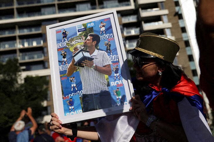 &copy; Reuters. A supporter of Serbian tennis player Novak Djokovic holds his photo during a rally outside the Park Hotel, where the star athlete is believed to be held while he stays in Australia, in Melbourne, Australia, January 9, 2022.  REUTERS/Loren Elliott