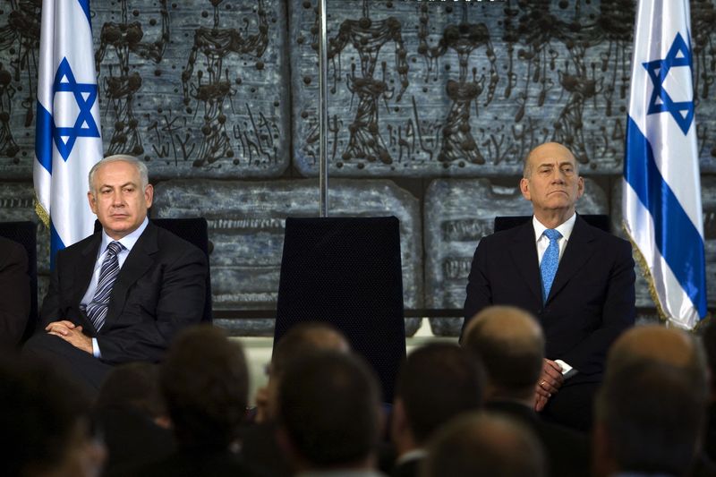 &copy; Reuters. إيهود أولمرت إلى اليمين وبنيامين نتنياهو إلى اليسار خلال مراسم انتقال السلطة بينهما في 2009. صورة من أرشيف رويترز