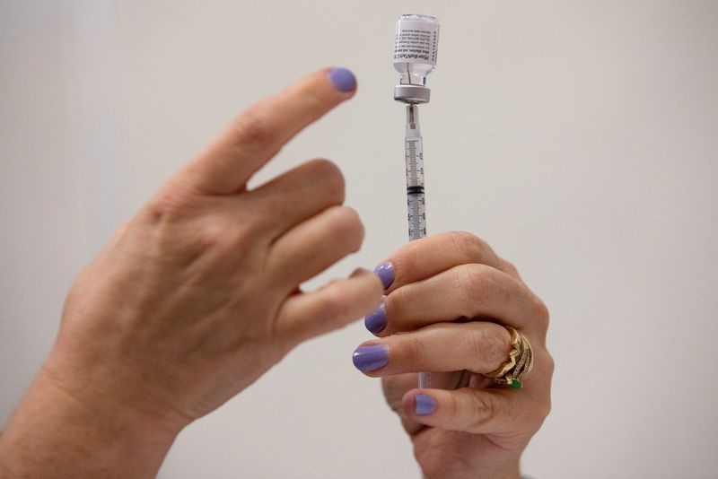 © Reuters. FILE PHOTO: A nurses fills up syringes for patients as they receive their coronavirus disease (COVID-19) booster vaccination during a Pfizer-BioNTech vaccination clinic in Southfield, Michigan, U.S., September 29, 2021. REUTERS/Emily Elconin