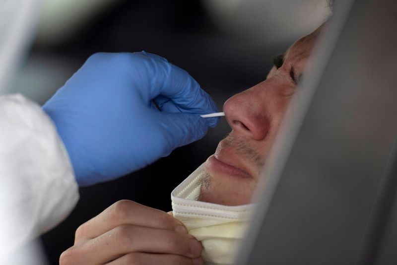 &copy; Reuters. FILE PHOTO: A man has his nose swabbed as people wait in their vehicles in long lines for the coronavirus disease (COVID-19) testing in Houston, Texas, U.S., July 7, 2020.  REUTERS/Callaghan O'Hare