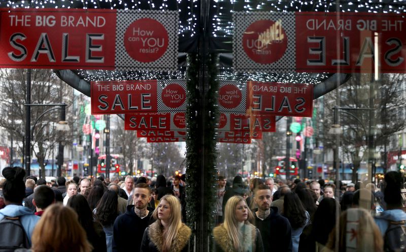 &copy; Reuters. FILE PHOTO: Shoppers are reflected in a store window as they pass sales advertisements on Oxford Street in London, Britain, December 26, 2015. REUTERS/Neil Hall