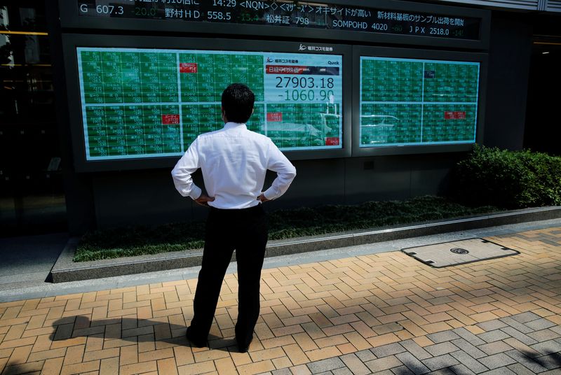 &copy; Reuters. Imagen de archivo de un hombre mirando una pantalla electrónica que muestra la cotización del índice Nikkei afuera de una correduría en un distrito de negocios en Tokio, Japón. 21 de junio, 2021. REUTERS/Kim Kyung-Hoon
