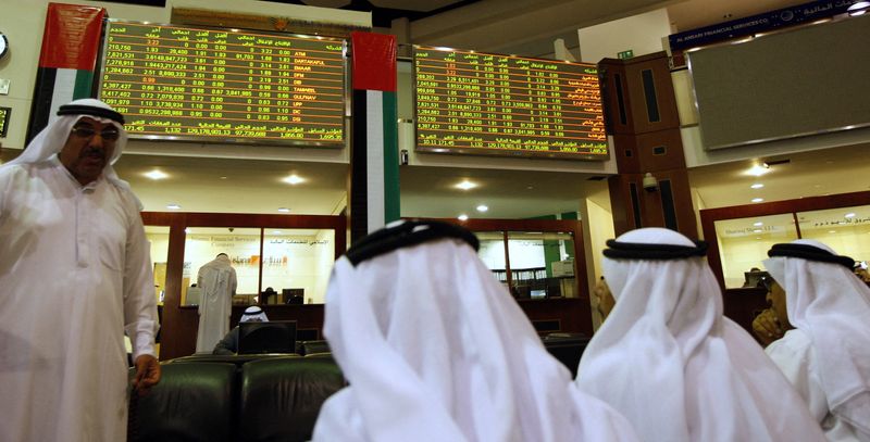 © Reuters. مستثمرون ينظرون إلى شاشة تعرض أسعار الأسهم في سوق أبوظبي للأوراق المالية في صورة من أرشيف رويترز.