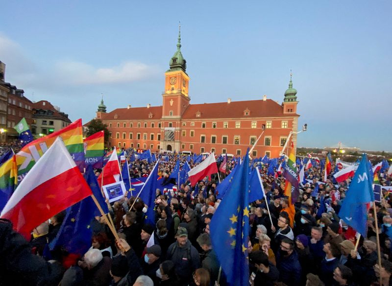 &copy; Reuters. FILE PHOTO: People carry flags and signs, as they take part in a rally in support of Poland's membership in the European Union after the country's Constitutional Tribunal ruled on the primacy of the constitution over EU law, undermining a key tenet of Eur