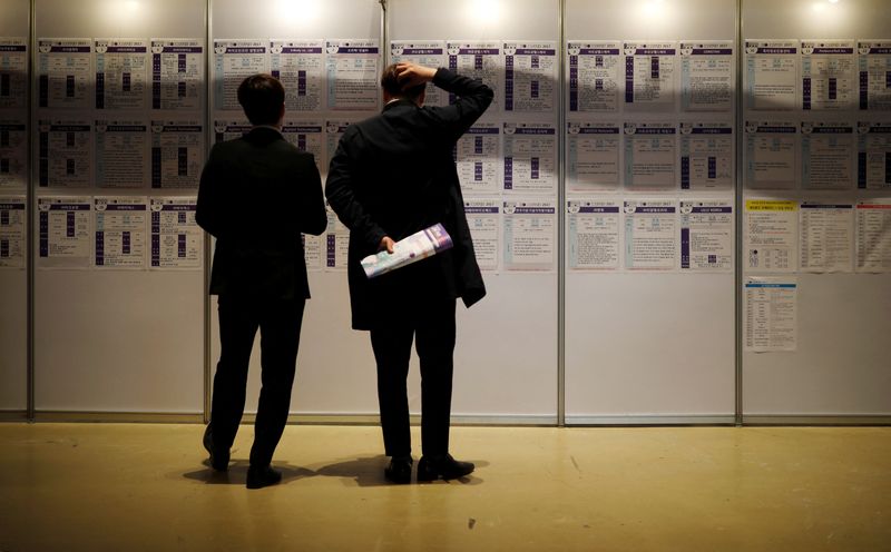 &copy; Reuters. FILE PHOTO: Men look at recruiting information during a job fair in Seoul, South Korea, April 12, 2017.  REUTERS/Kim Hong-Ji