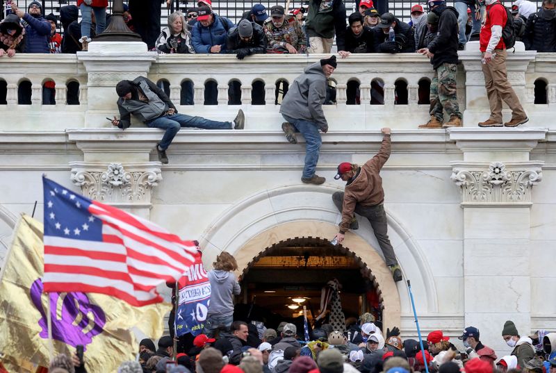 © Reuters. حشد من أنصار الرئيس الأمريكي دونالد ترامب يواجهون أفراد من أجهزة إنفاذ القانون أثناء اقتحامهم مبنى الكابيتول في واشنطن في 6 يناير كانون الثاني 2021. تصوير:رويترز.