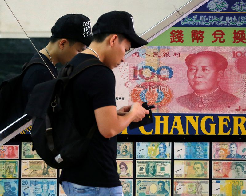&copy; Reuters. FILE PHOTO: A man passes a money changer displaying a poster of a 100 yuan bill in Singapore April 28, 2016. REUTERS/Edgar Su