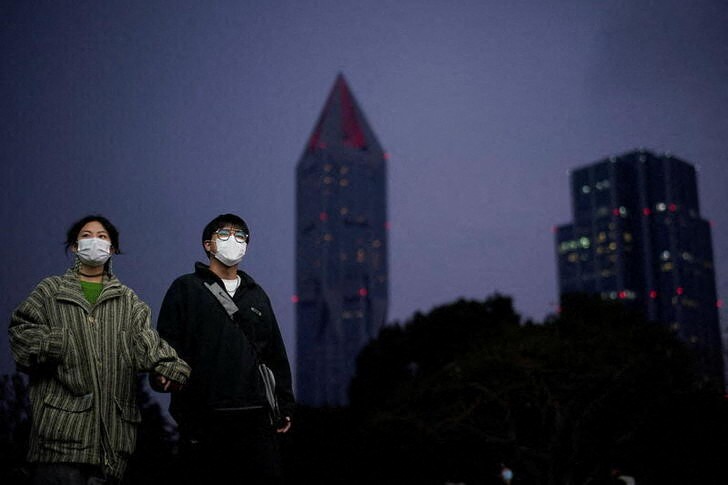 &copy; Reuters. People wearing protective masks walk on a street, following new cases of the coronavirus disease (COVID-19), in Shanghai, China January 4, 2022. REUTERS/Aly Song