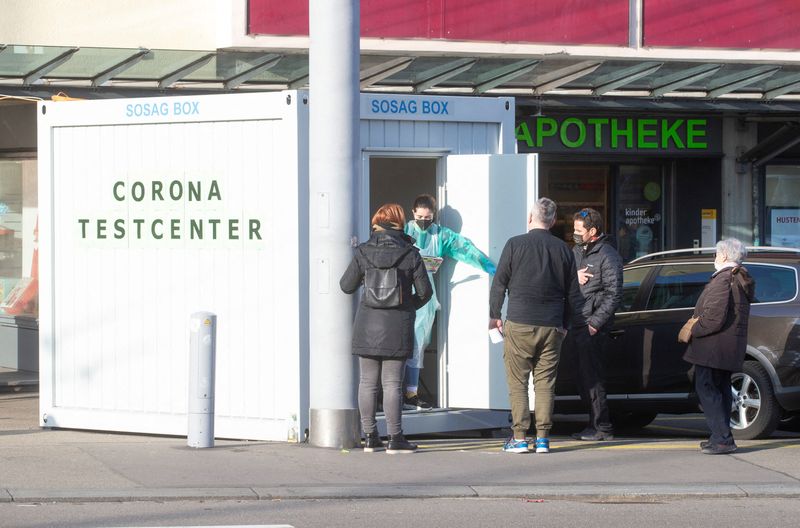 &copy; Reuters. FILE PHOTO: People stand in front of a container, that is being used for coronavirus disease (COVID-19) tests, next to a pharmacy in Zurich, Switzerland December 20, 2021. REUTERS/Arnd Wiegmann