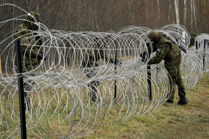 &copy; Reuters. Estonian army reservists build a temporary razor wire fence on a border with Russia during a snap military exercise Okas 2021 near Meremae, Estonia November 20, 2021. REUTERS/Ints Kalnins