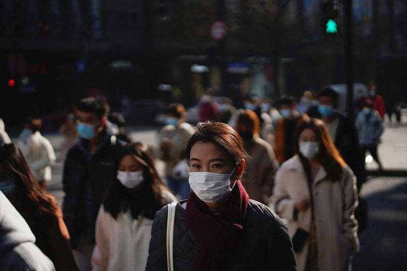 &copy; Reuters. FOTO DE ARCHIVO. Imagen referencial de personas con mascarillas caminando por una calle, en Shanghái, China. 20 de diciembre de 2021. REUTERS/Aly Song