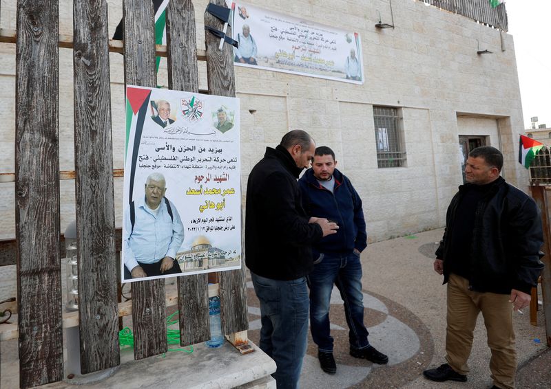 &copy; Reuters. رجال يقفون بجانب ملصق للفلسطيني عمر عبد المجيد أسعد (80 عاما) في قرية جلجليا بالضفة الغربية المحتلة يوم الأربعاء. تصوير: محمد توركمان - رويترز.