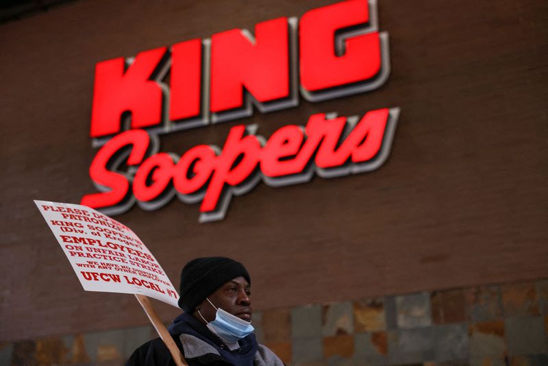 © Reuters. A union member raises a sign outside a Kroger's King Soopers store during a protest as workers go on strike in Denver, Colorado, U.S., January 12, 2022.  REUTERS/Kevin Mohatt