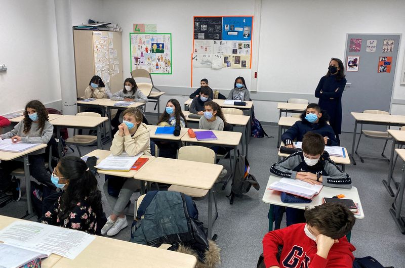 &copy; Reuters. FILE PHOTO: Schoolchildren, wearing protective face masks, work in a classroom at the College Jean Renoir Middle School in Boulogne-Billancourt, near Paris, France, January 7, 2022. REUTERS/Yiming Woo//File Photo