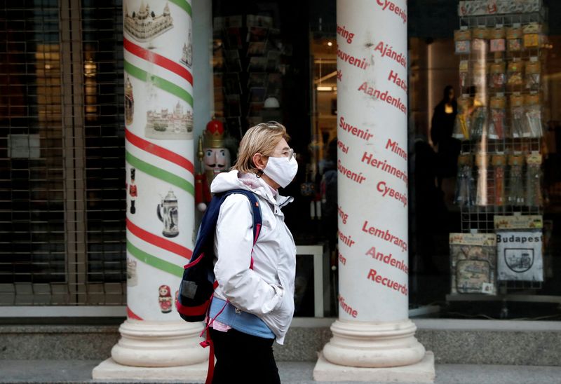 © Reuters. FILE PHOTO: A woman wearing a protective face mask walks in downtown Budapest, after Hungarian government imposed a nationwide lockdown to contain the spread of the coronavirus disease (COVID-19), Hungary, November 11, 2020. REUTERS/Bernadett Szabo