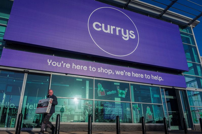 © Reuters. FILE PHOTO: A person carries a television outside a Currys store in London, Britain, November 22, 2021. Picture taken November 22, 2021. REUTERS/May James