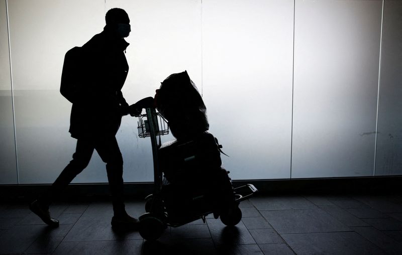 &copy; Reuters. Un uomo con diversi bagagli all'aeroporto di Fiumicino. REUTERS/Remo Casilli