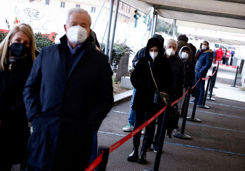 &copy; Reuters. Una fila di persone in attesa di ricevere una dose di richiamo contro il Covid-19 presso un centro di vaccinazione a Roma. REUTERS/Guglielmo Mangiapane