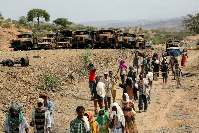&copy; Reuters. FILE PHOTO: Villagers return from a market to Yechila town in south central Tigray walking past scores of burned vehicles, in Tigray, Ethiopia, July 10, 2021. REUTERS/Giulia Paravicini/File Photo/File Photo