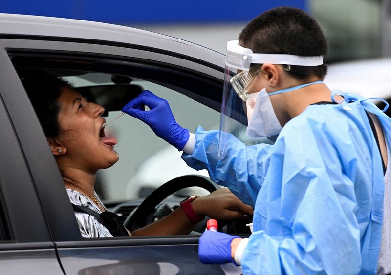 &copy; Reuters. FILE PHOTO: A woman takes a test for the coronavirus disease (COVID-19) at a testing centre in Sydney, Australia, January 5, 2022.  REUTERS/Jaimi Joy 