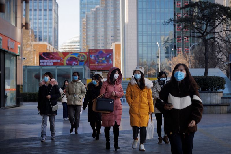 &copy; Reuters. IMAGEN DE ARCHIVO. Personas caminan utilizando mascarillas en una calle de Pekín, China, Enero13, 2022. REUTERS/Thomas Peter