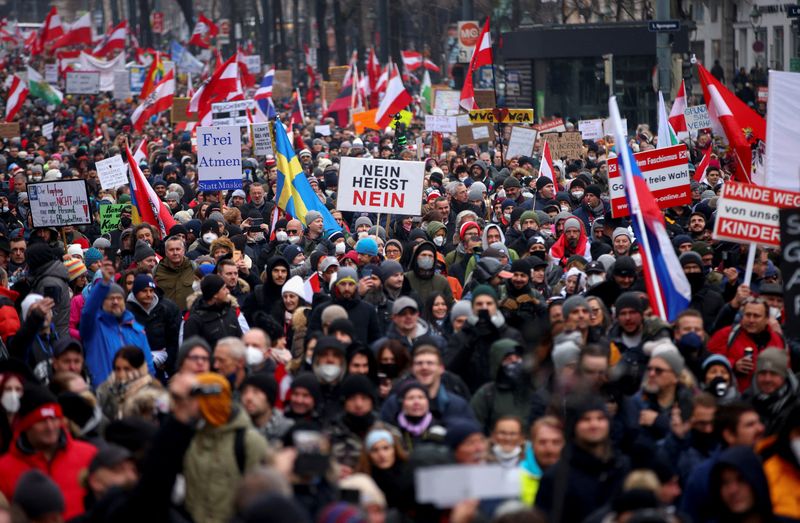 &copy; Reuters. محتجون يرفعون لافتات وأعلام في مسيرة للاحتجاج على القيود التي فرضتها الحكومة بسبب فيروس كورونا والتطعيم الإلزامي في فيينا عاصمة النمسا يوم