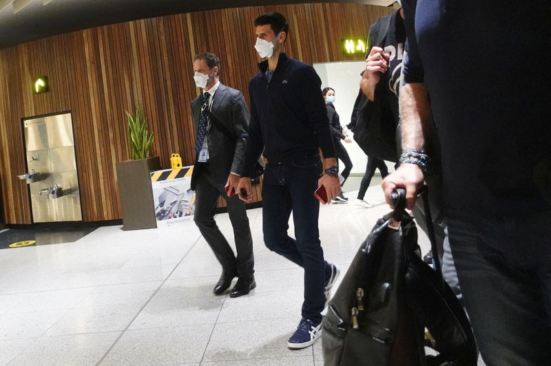 © Reuters. Serbian tennis player Novak Djokovic walks in Melbourne Airport before boarding a flight, after the Federal Court upheld a government decision to cancel his visa to play in the Australian Open, in Melbourne, Australia, January 16, 2022. REUTERS/Loren Elliott