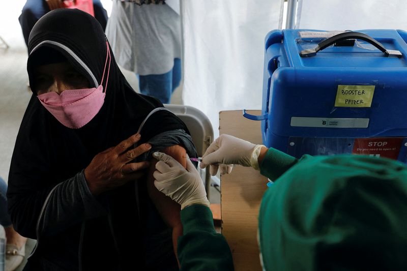 &copy; Reuters. امرأة تتلقى لقاحا للوقاية من فيروس كورونا في جاكرتا يوم 12 يناير كانون الثاني 2022. تصوير: ويلي كورنياوان - رويترز.