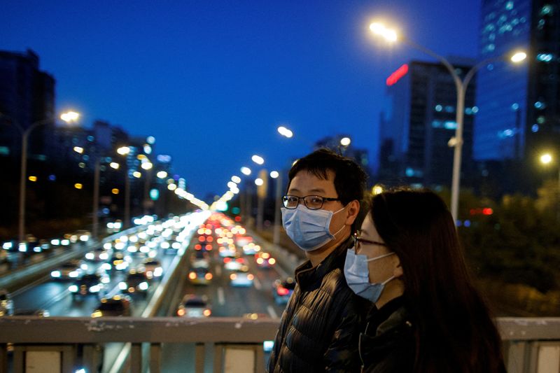 &copy; Reuters. شخصان يضعان كمامتين يعبران جسرا في بكين بصورة من أرشيف رويترز.