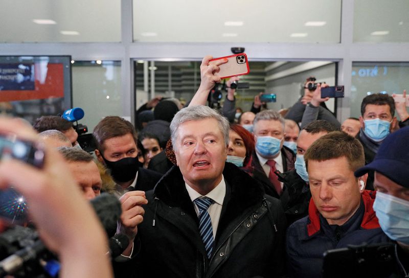 &copy; Reuters. الرئيس الأوكراني السابق بيترو بوروشينكو يتحدث للصحفيين لدى وصوله إلى مطار في كييف يوم الاثنين. تصوير: جليب جارانيتش - رويترز.
