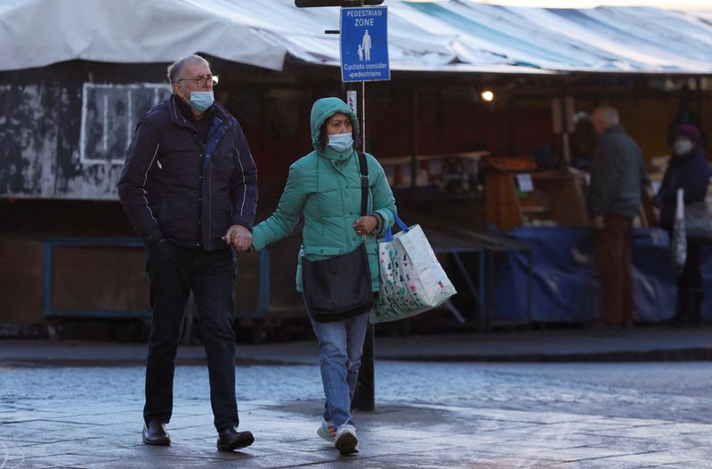 © Reuters. رجل وامرأة يرتديان الكمامة خلال تسوقهما في كامبريدج ببريطانيا يوم 14 يناير كانون الثاني 2022. تصوير:رويترز.
