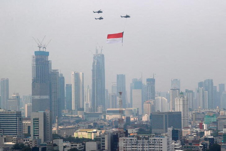 &copy; Reuters. 　インドネシア議会は首都をジャカルタからボルネオ島のカリマンタンに移転する法案を可決した。写真は昨年８月１７日に開かれた独立記念日の式典で、国旗を掲げる空軍のヘリコプター