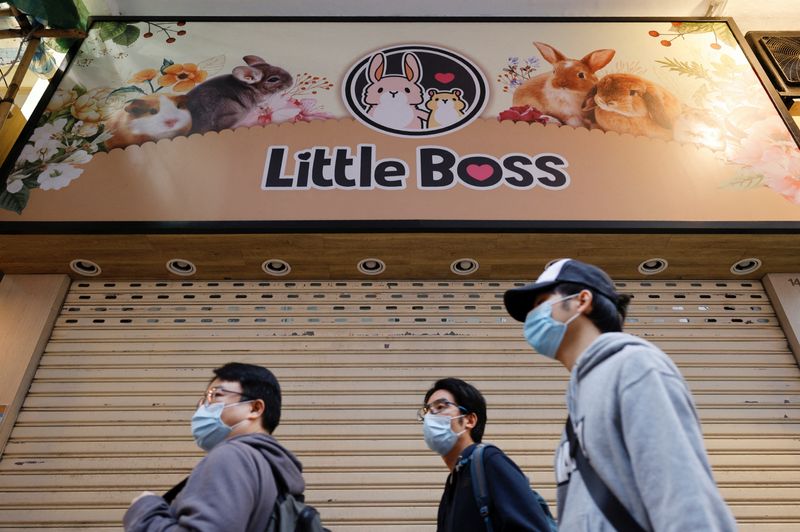 &copy; Reuters. Pessoas passam em frente a pet shop fechado em Hong Kong depois de governo anunciar o abate de 2 mil hamsters por causa da Covid-19
18/01/2022 REUTERS/Tyrone Siu