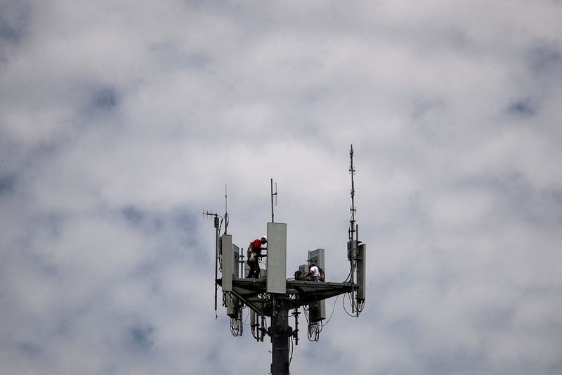 © Reuters. FILE PHOTO: Workers install 5G telecommunications equipment on a T-Mobile US Inc tower in Seabrook, Texas, U.S. May 6, 2020. REUTERS/Adrees Latif/File Photo