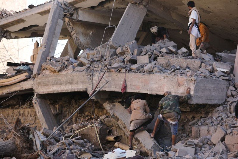 &copy; Reuters. Socorristas buscan sobrevivientes bajo el techo colapsado de una casa golpeada por ataques aéreos de la coalición liderada por Arabia Saudita en Saná, Yemen. 18 de enero, 2022. REUTERS/Khaled Abdullah