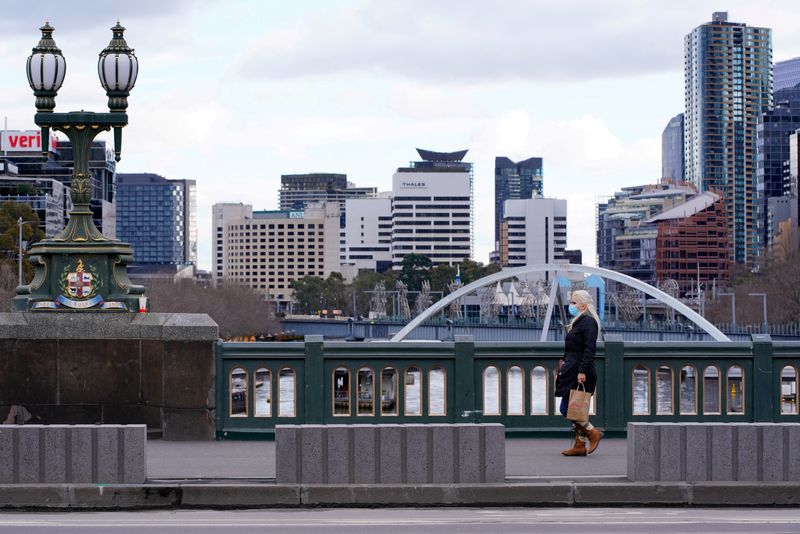 &copy; Reuters. Mulher usando máscara de proteção caminha sozinha em Melbourne em meio à pandemia de Covid-19
16/07/2021 REUTERS/Sandra Sanders