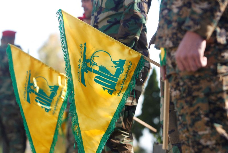 © Reuters. عضوان في حزب الله يمسكان علمين للجماعة في كفركلا بجنوب لبنان قرب الحدود مع إسرائيل يوم 25 مايو أيار 2021. تصوير: عزيز طاهر - رويترز. 
