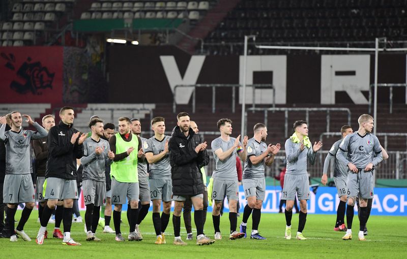 © Reuters. لاعبو سانت باولي يحتفلون عقب الفوز على بروسيا دورتموند في دور 16 لكأس ألمانيا لكرة القدم في هامبورج يوم الثلاثاء.تصوير:رويترز.