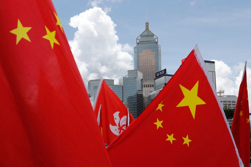 &copy; Reuters. FILE PHOTO: Buildings are seen above Hong Kong and Chinese flags, as pro-China supporters celebration after China's parliament passes national security law for Hong Kong, in Hong Kong, China June 30, 2020. REUTERS/Tyrone Siu