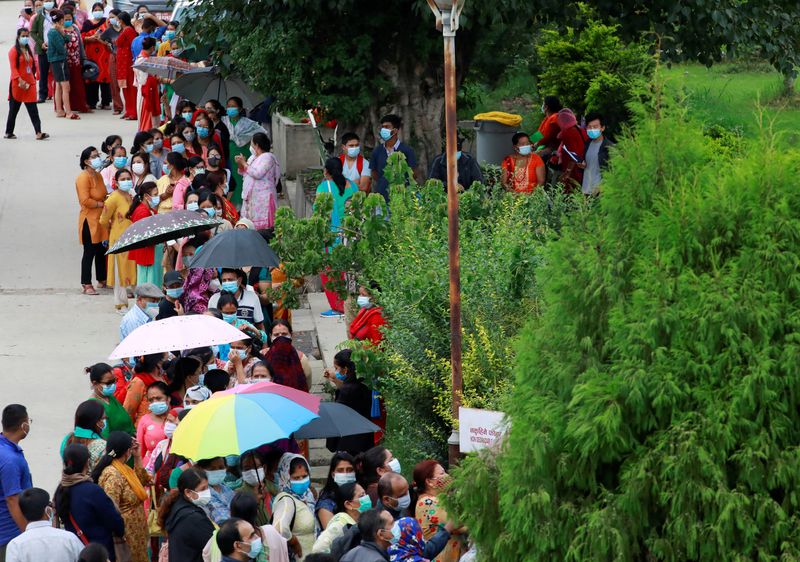 &copy; Reuters. FOTO DE ARCHIVO: Personas esperando en una fila a vacunarse contra el COVID-19 en Katmandú, Nepal, el 13 de julio de 2021. REUTERS/Navesh Chitrakar