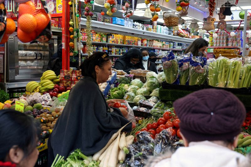 © Reuters. FILE PHOTO: People shop at a supermarket in London, Britain December 24, 2021. REUTERS/Kevin Coombs/File Photo