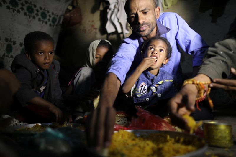 &copy; Reuters. أفراد أسرة إسماعيل حسن يتناولون الغداء في مأواهم في صنعاء يوم 17 يناير كانون الثاني 2022. تصوير: خالد عبدالله - رويترز.