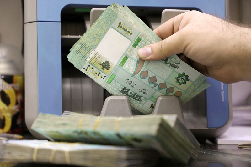 &copy; Reuters. رجل يحصي أوراقا نقدية من العملة اللبنانية في مكتب للصرافة في بيروت في الخامس من يناير كانون الثاني 2022. تصوير محمد عزاقير - رويترز.