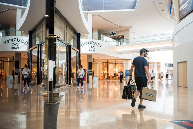 &copy; Reuters. FILE PHOTO: A shopper exits a store holding multiple shopping bags in Sherway Gardens mall during the stage two reopening from coronavirus disease (COVID-19) restrictions in Toronto, Ontario, Canada June 30, 2021. REUTERS/Alex Filipe